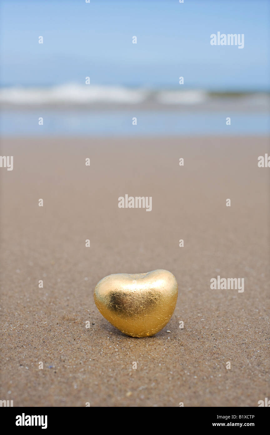 Goldenes Herz geformte Kiesel am Strand von Findhorn, Schottland Stockfoto