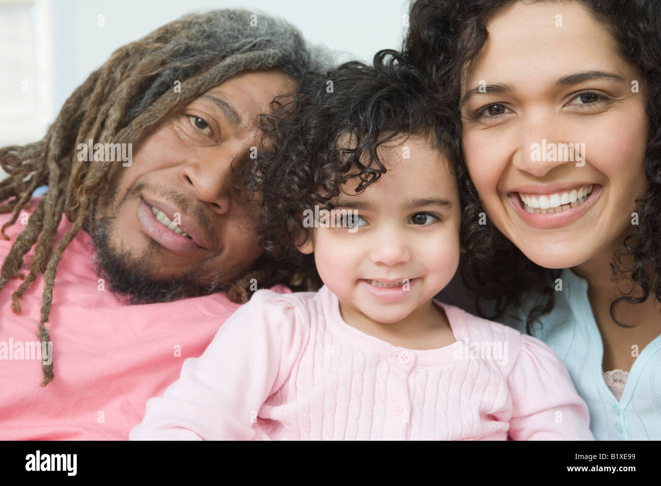 Porträt eines Mitte Erwachsenen Paares lächelnd mit ihrer Tochter Stockfoto