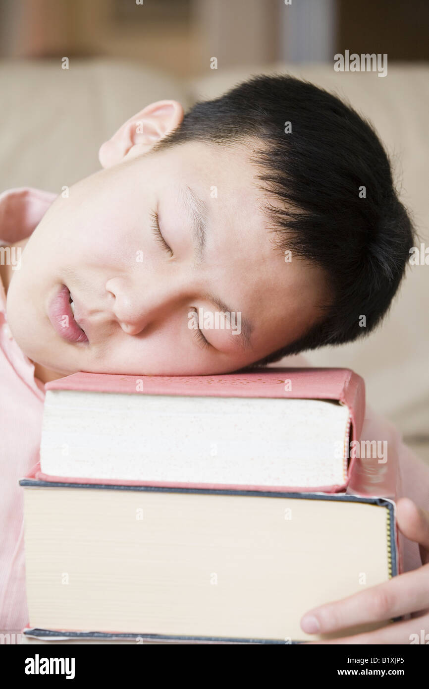 Nahaufnahme von einem Teenager schlafen auf einem Stapel Bücher Stockfoto