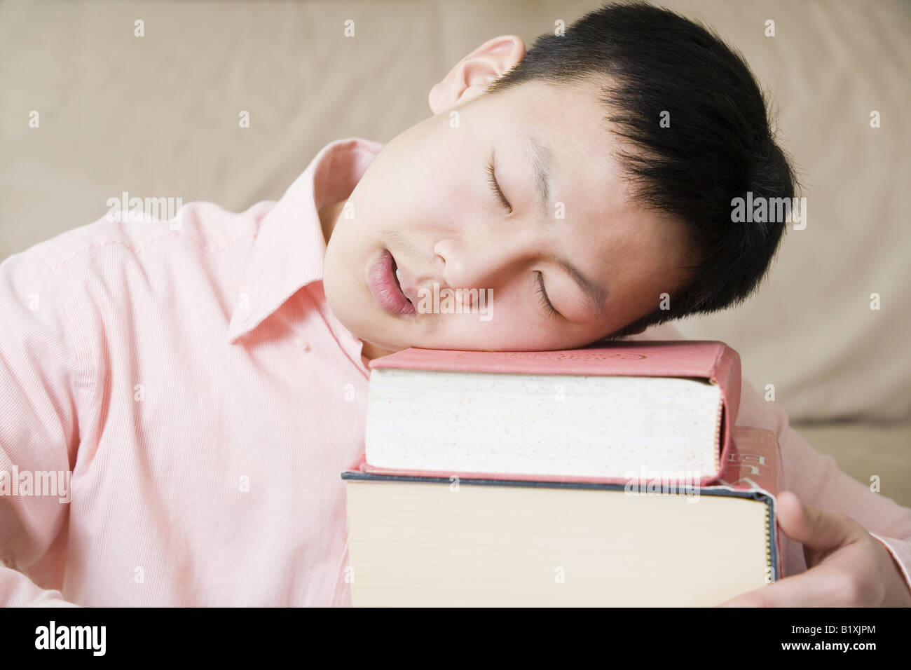 Nahaufnahme von einem Teenager schlafen auf einem Stapel Bücher Stockfoto