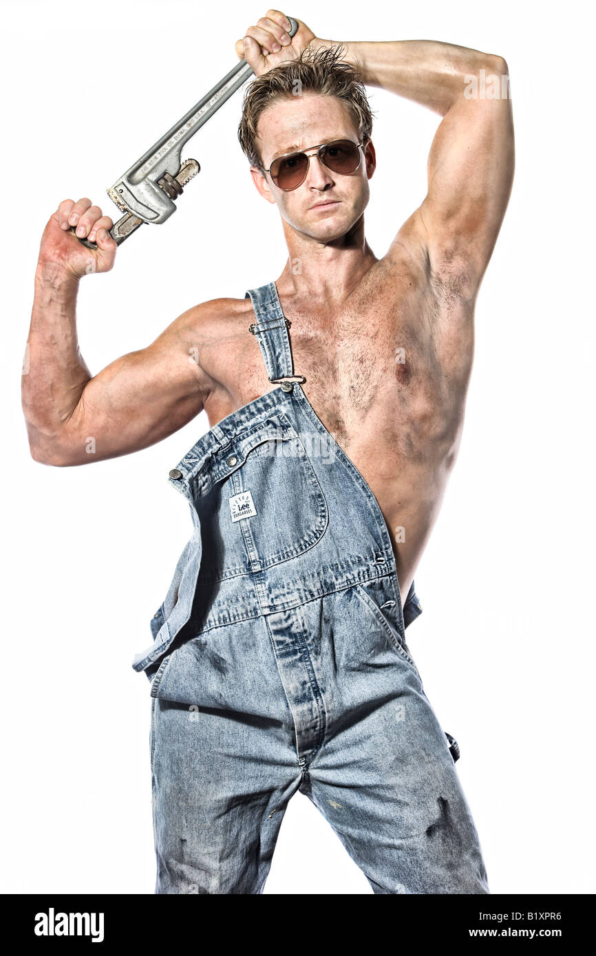 Sexy fettig kaukasischen Mann 30 etwas Handwerker Klempner mit seiner  Werkzeuge Schraubenschlüssel Lätzchen Jeans und Pilotenbrille  Stockfotografie - Alamy