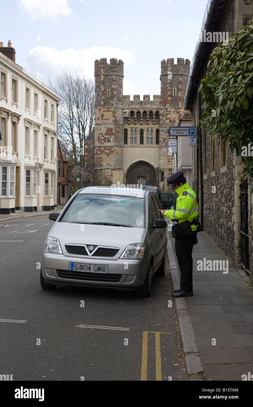 Traffic Warden ein Ticket für ein Auto, geparkt auf doppelte gelbe Linien in einer Straße in Canterbury Kent bestimmt schreiben Stockfoto
