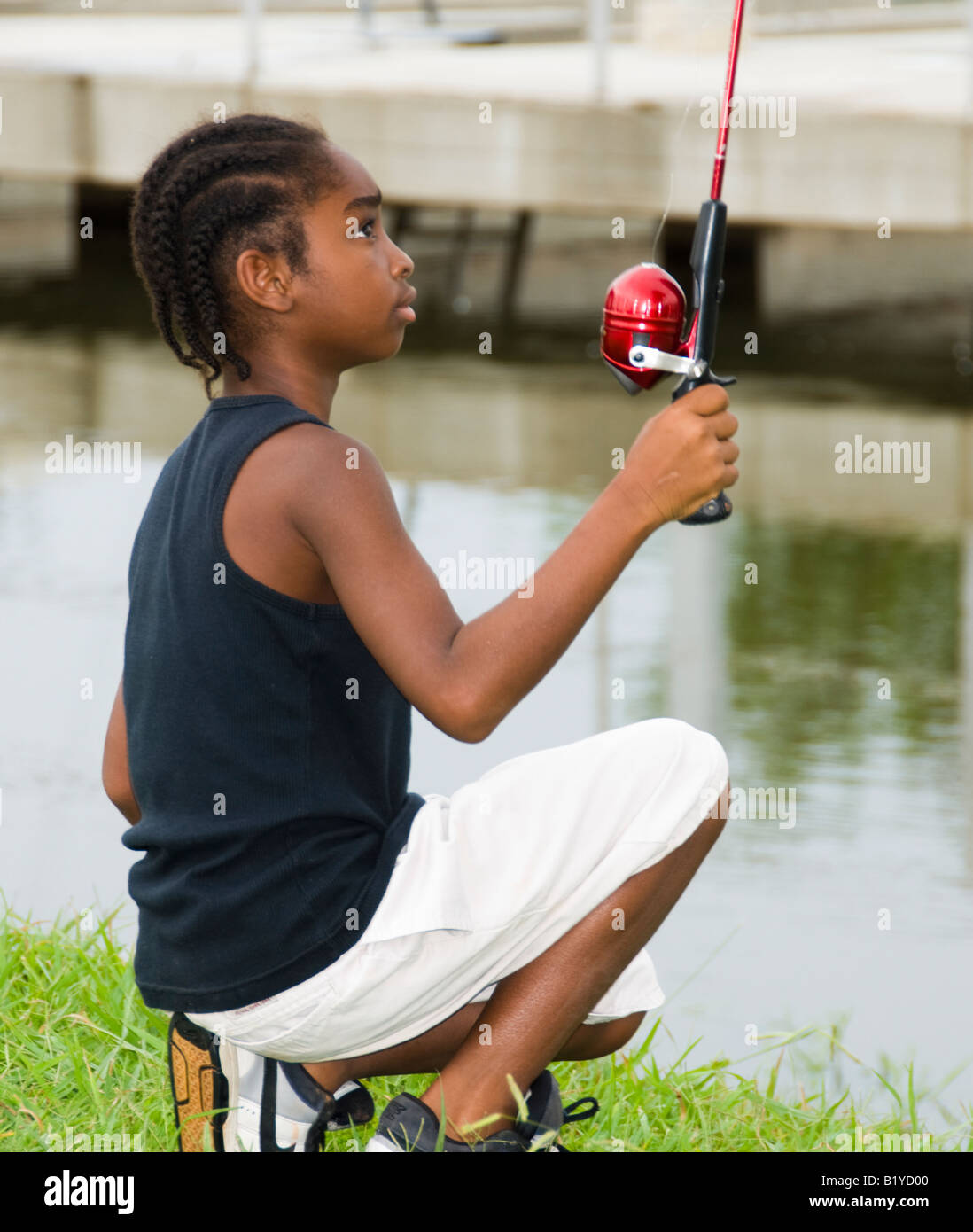 Eine junge, 9-12 Jahr alte afroamerikanische Junge Fische in der Nähe von Boot docks Oklahoma City, Oklahoma, USA. Stockfoto