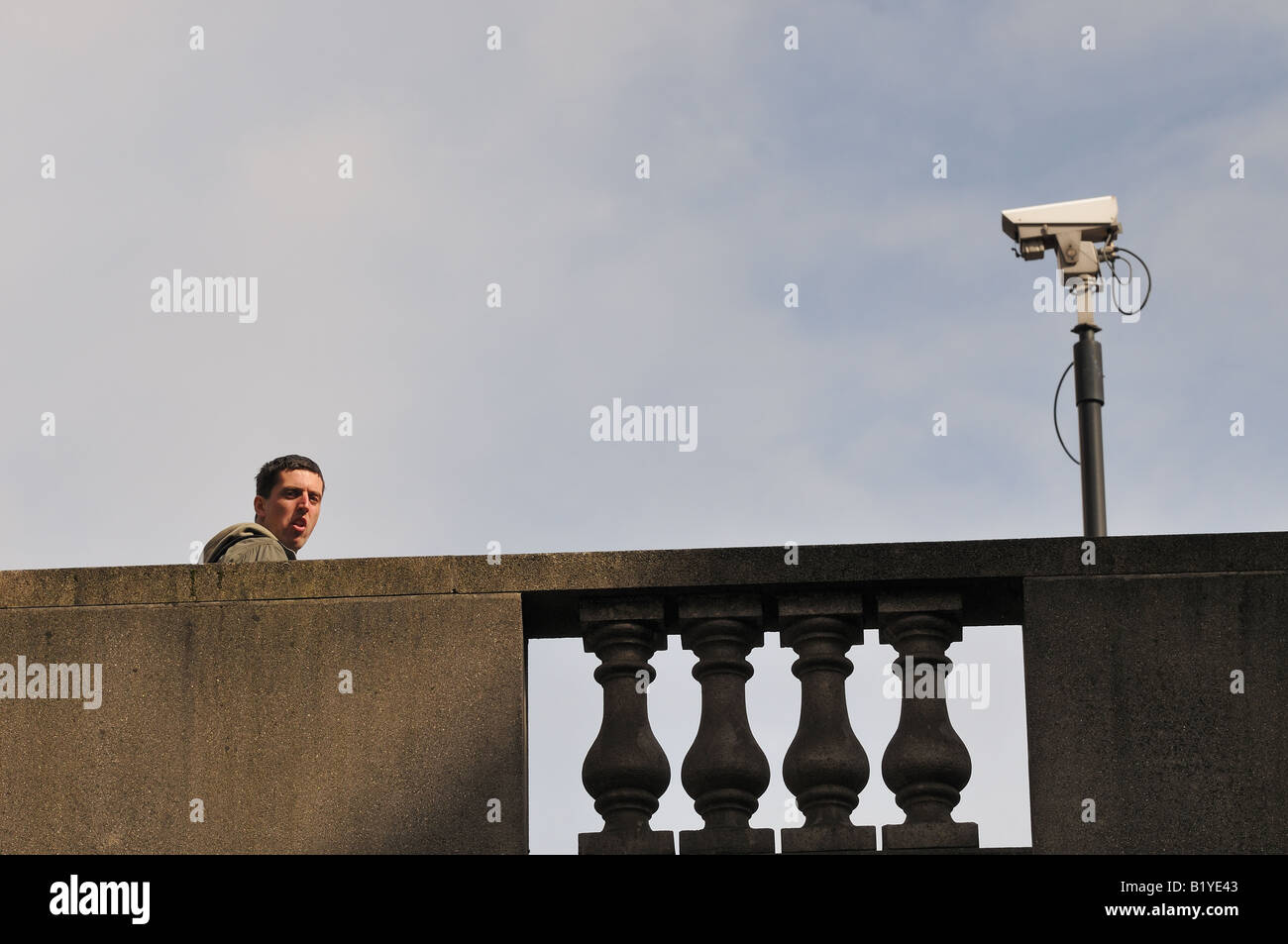 Mann auf einer Brücke mit einer CCTV-Kamera Stockfoto