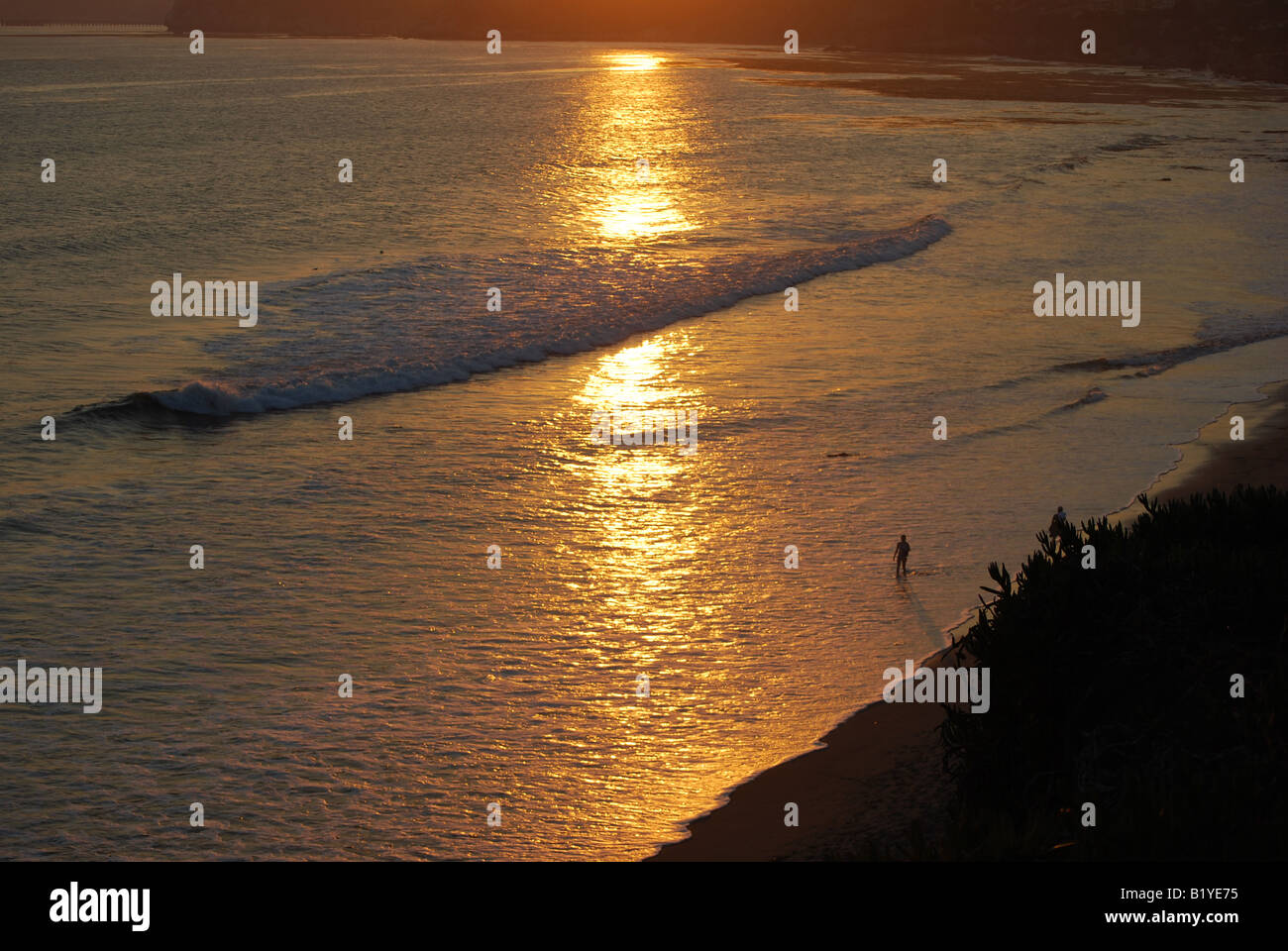 Mädchen zu Fuß am Strand bei Sonnenuntergang Stockfoto