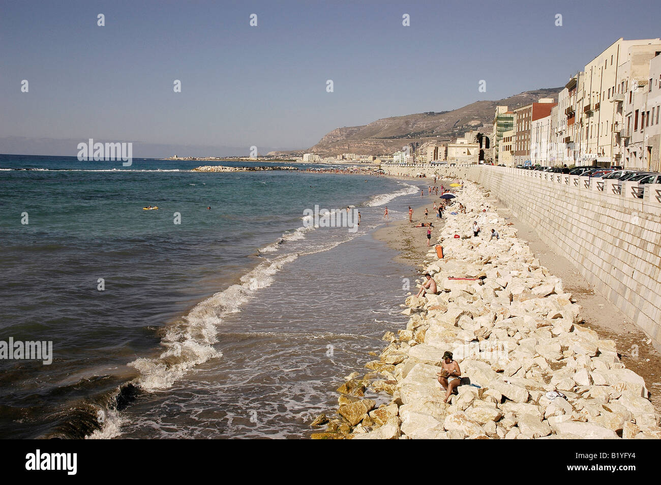 Sonnenanbeter am felsigen Strand von Trapani, Sizilien Stockfoto