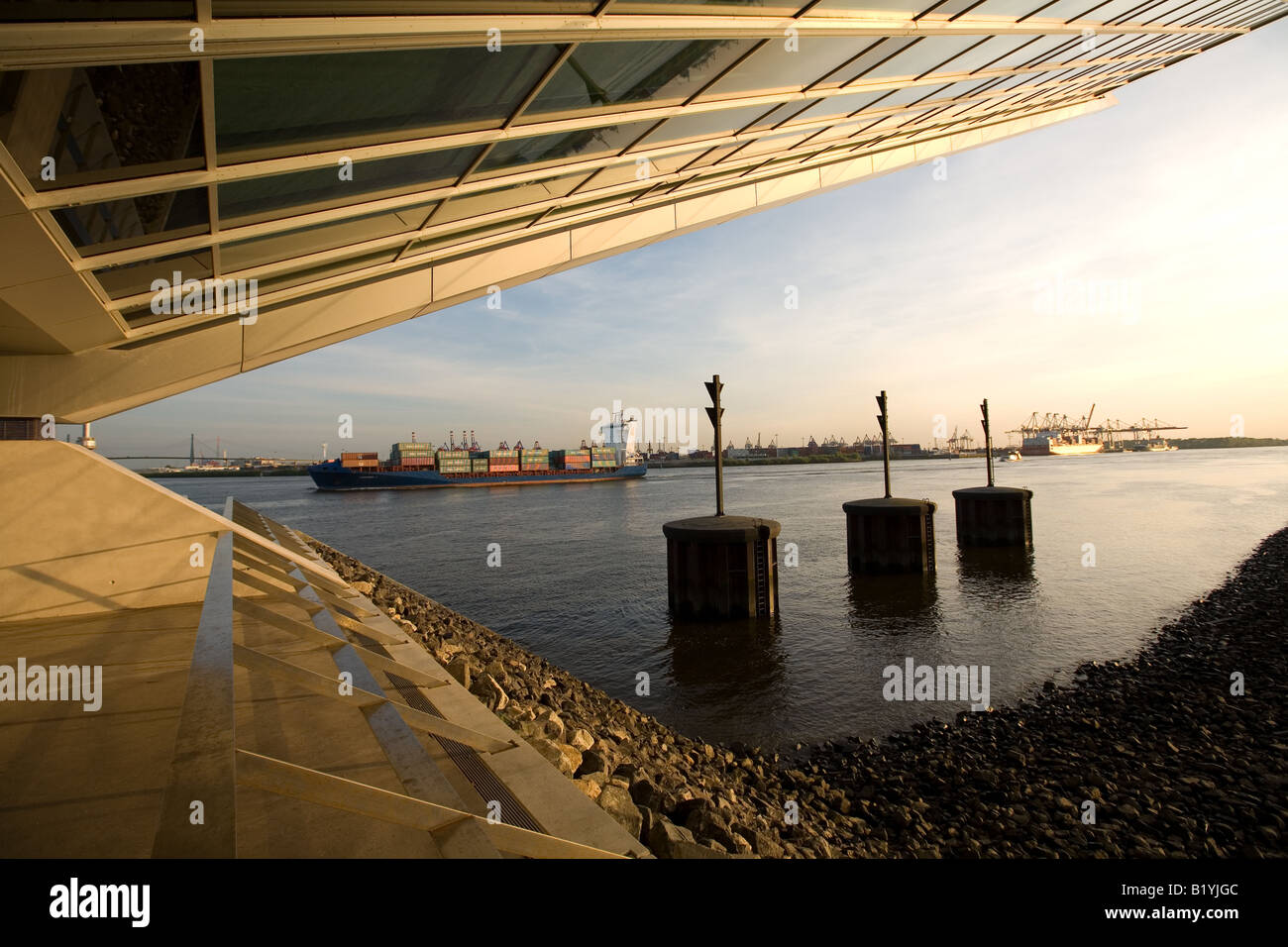 Container-Frachter vorbei das Dockland Bürogebäude an der Elbe in Hamburg Stockfoto