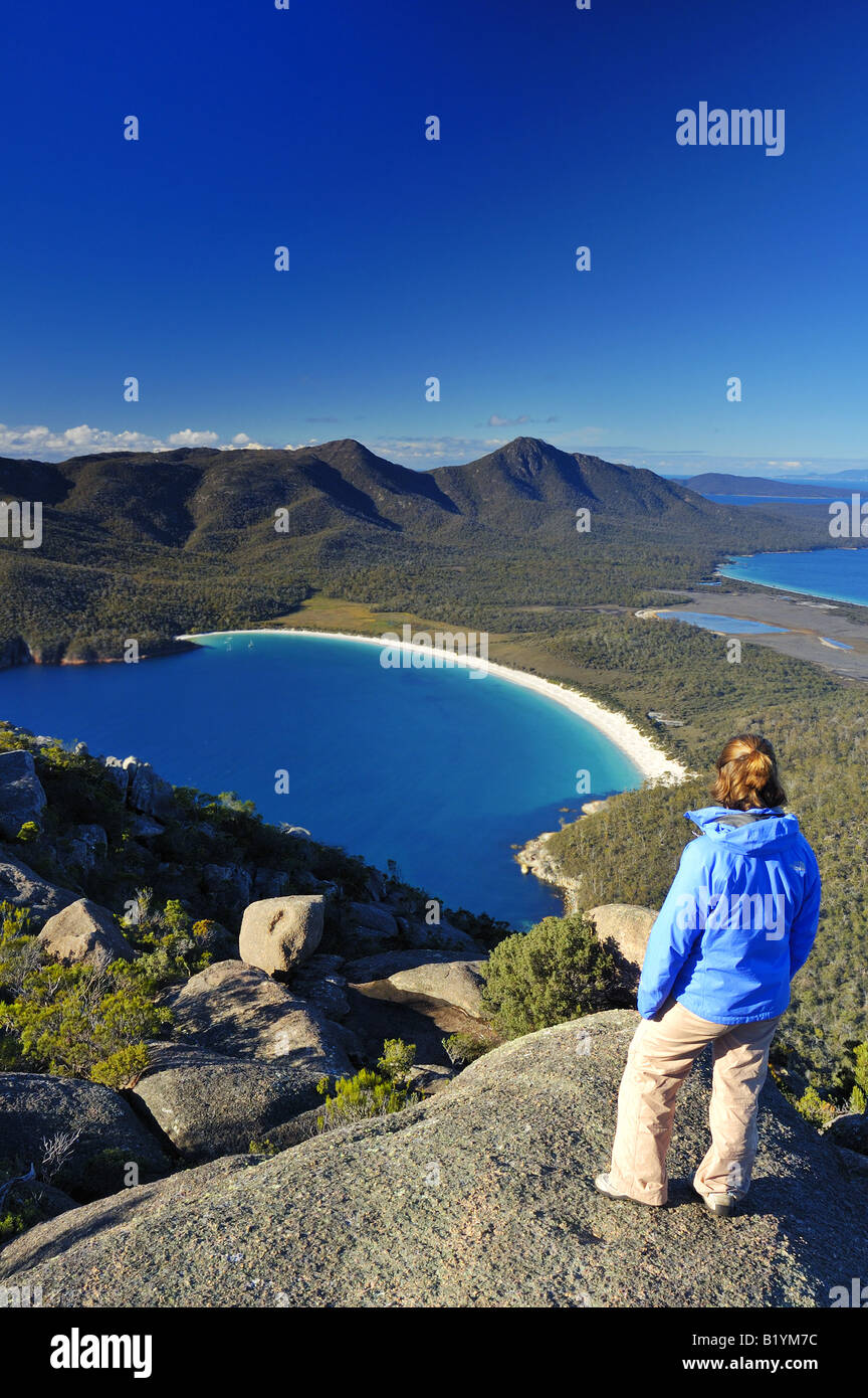 Ein Bergsteiger schaut auf Wineglass Bay, Tasmanien, von der Spitze des Mount Amos. Stockfoto