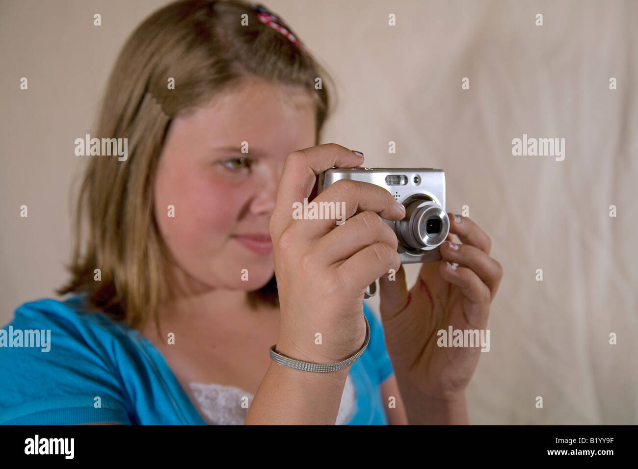 Ein junges Mädchen schießt ein Foto mit einer neuen Generation 8-Megapixel-Digitalkamera mit Handschlaufe Stockfoto