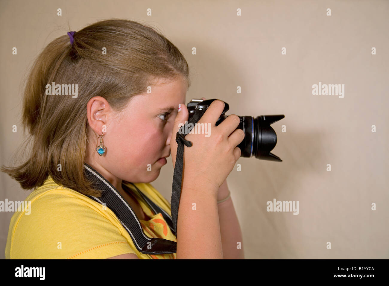 Ein junges Mädchen nimmt ein Foto mit einer digitalen SLR-Kamera Stockfoto