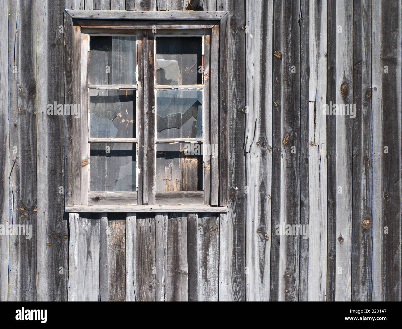 alte hölzerne Scheune Fenster mit Brille geknackt Stockfoto