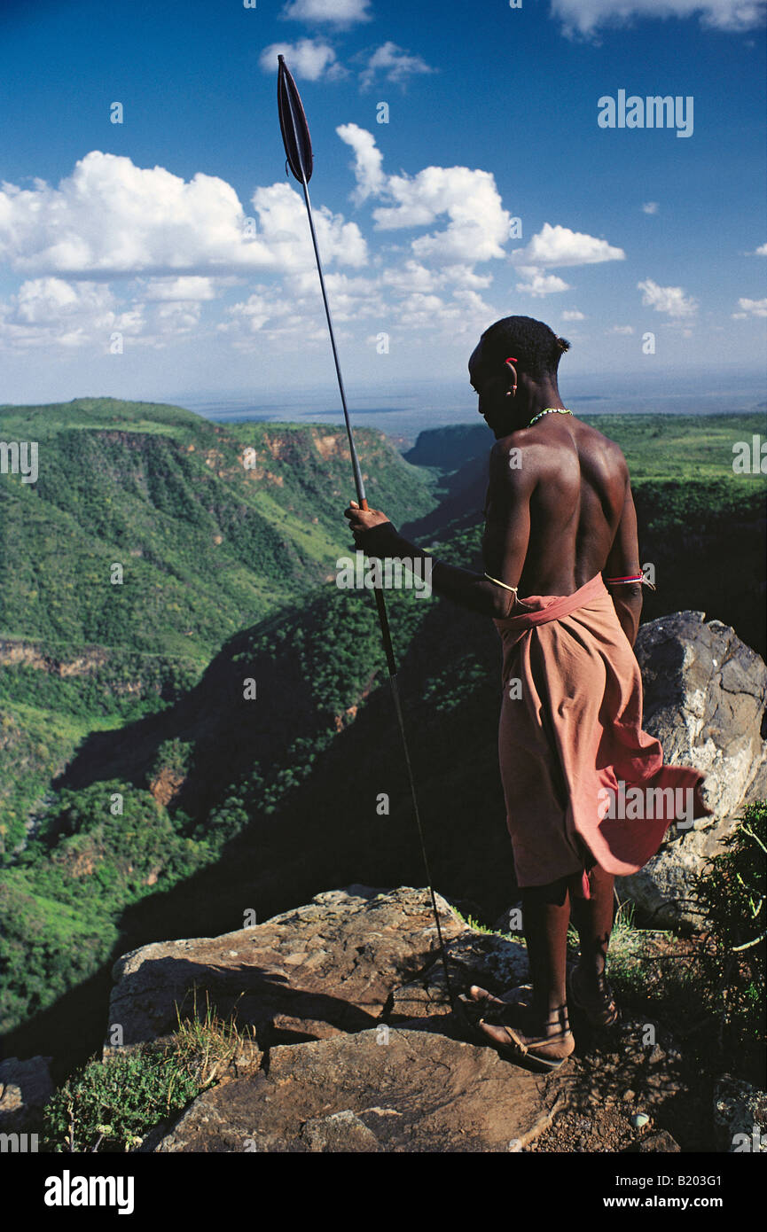 Samburu Krieger oder Moran in traditioneller Kleidung bewaffnet mit einem Speer auf der Suche nach unten die El Kajarta Schlucht nördlichen Kenia in Ostafrika Stockfoto