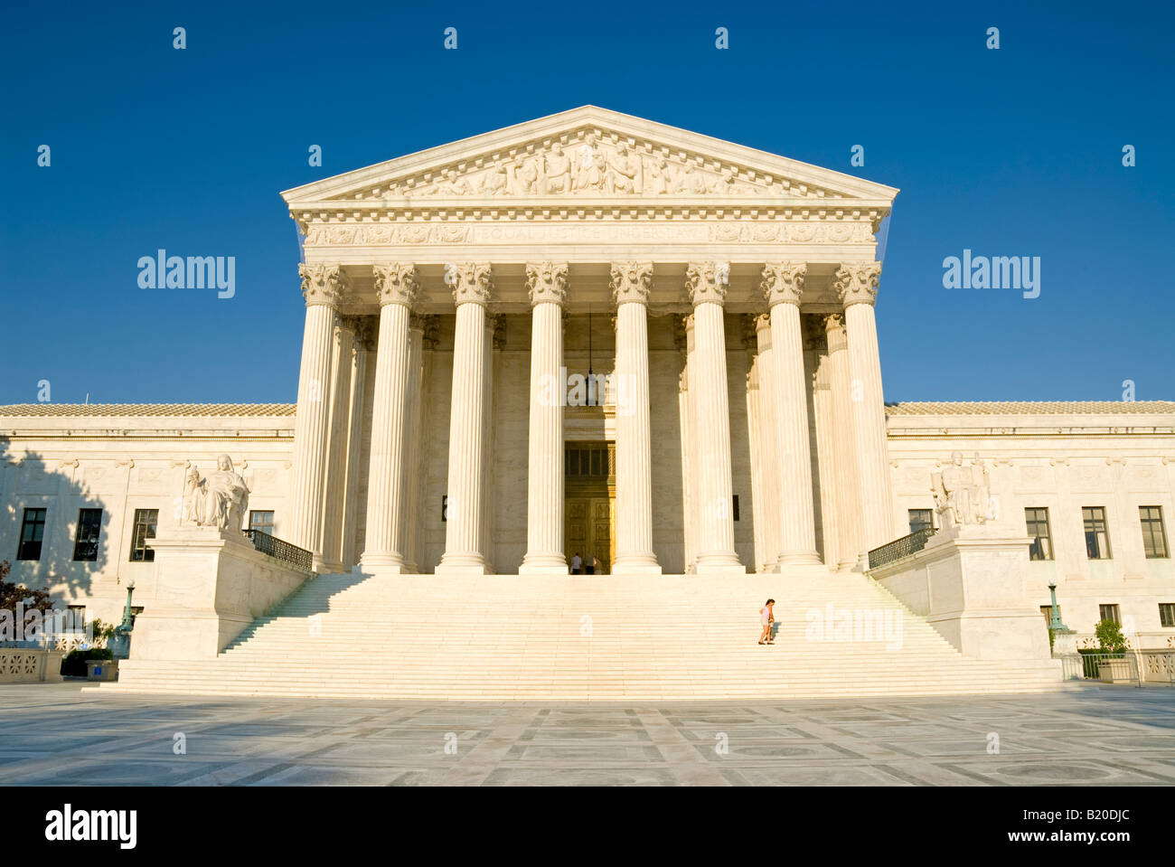 Fassade des US Supreme Court Building Washington DC // WASHINGTON DC – das Gebäude des US Supreme Court befindet sich auf dem Capitol Hill in Washington DC und ist ein ikonisches Beispiel neoklassizistischer Architektur, entworfen von dem Architekten Cass Gilbert und fertiggestellt im Jahr 1935. Die große Fassade des Gebäudes verfügt über 16 hoch aufragende korinthische Säulen und eine Marmortreppe, die zum Eingang führt. Oberhalb des Haupteingangs ist der Ausdruck „gleiche Gerechtigkeit unter dem Gesetz“ eingeprägt, der die verfassungsmäßige Aufgabe des Gerichtshofs widerspiegelt. Das Gebäude dient als höchste Justizbehörde in den Vereinigten Staaten und ist ein bedeutendes Wahrzeichen in den USA Stockfoto