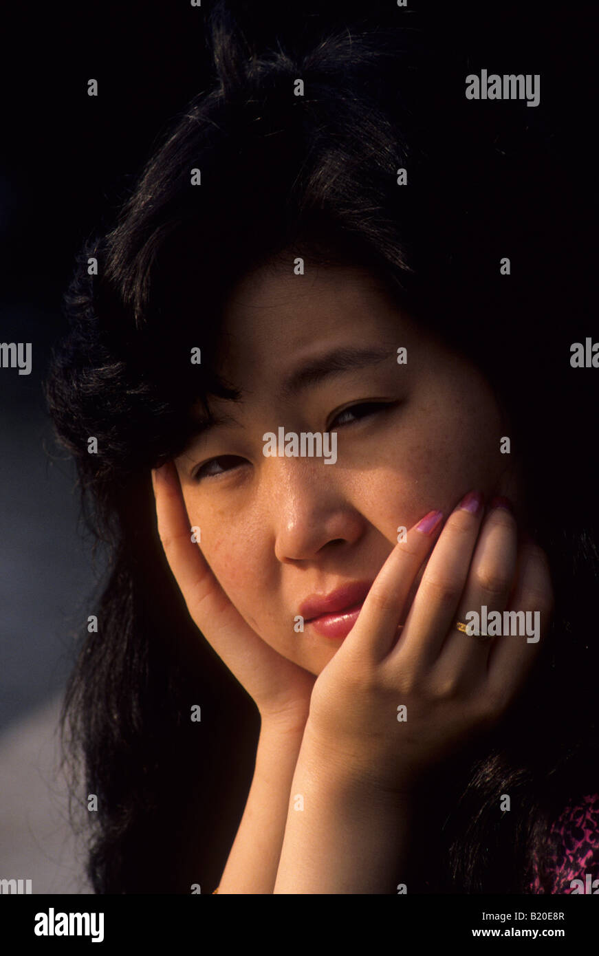 Eine chinesische Frau blickt in einem öffentlichen Park in Shanghai China Stockfoto