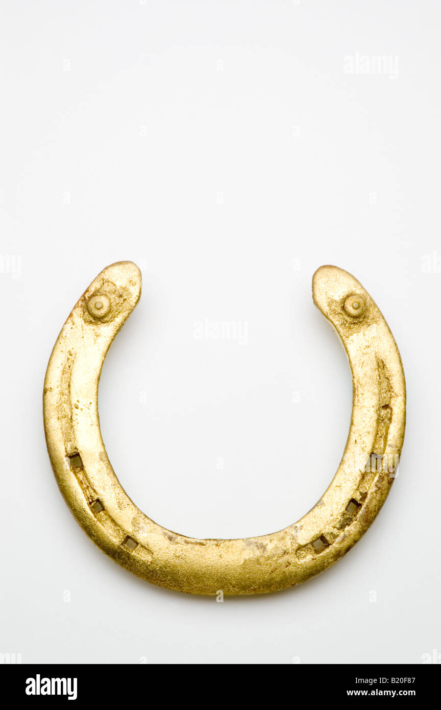 Goldene Hufeisen auf weißem Stockfoto