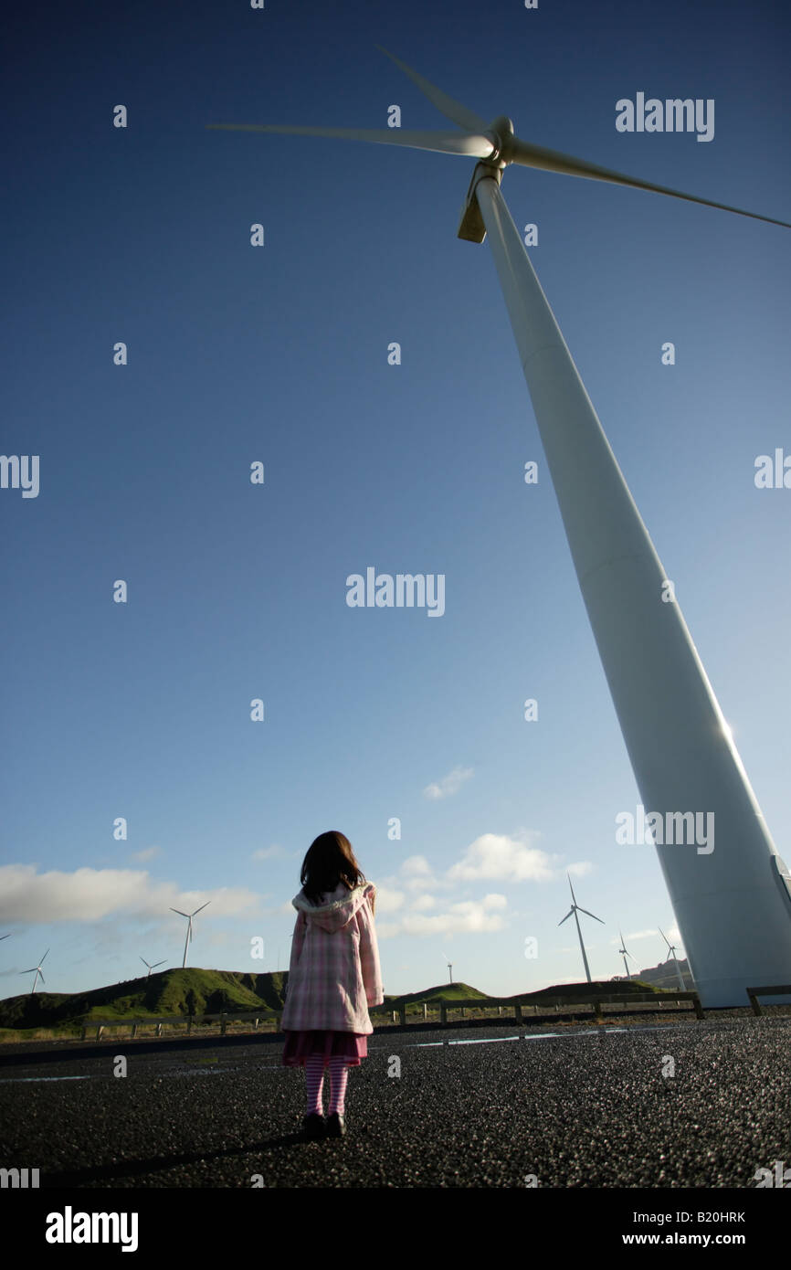 Mädchen untersucht eine Windmühle geöffnet für Besucher und schaut hoch aufragenden turbine Stockfoto