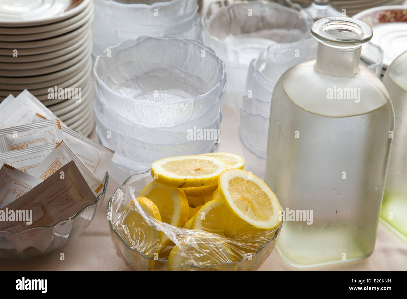 Spanien Madrid geschnittene Zitrone in Schüssel Glasflasche mit Wasserschalen und Pakete für Kellner im restaurant Stockfoto