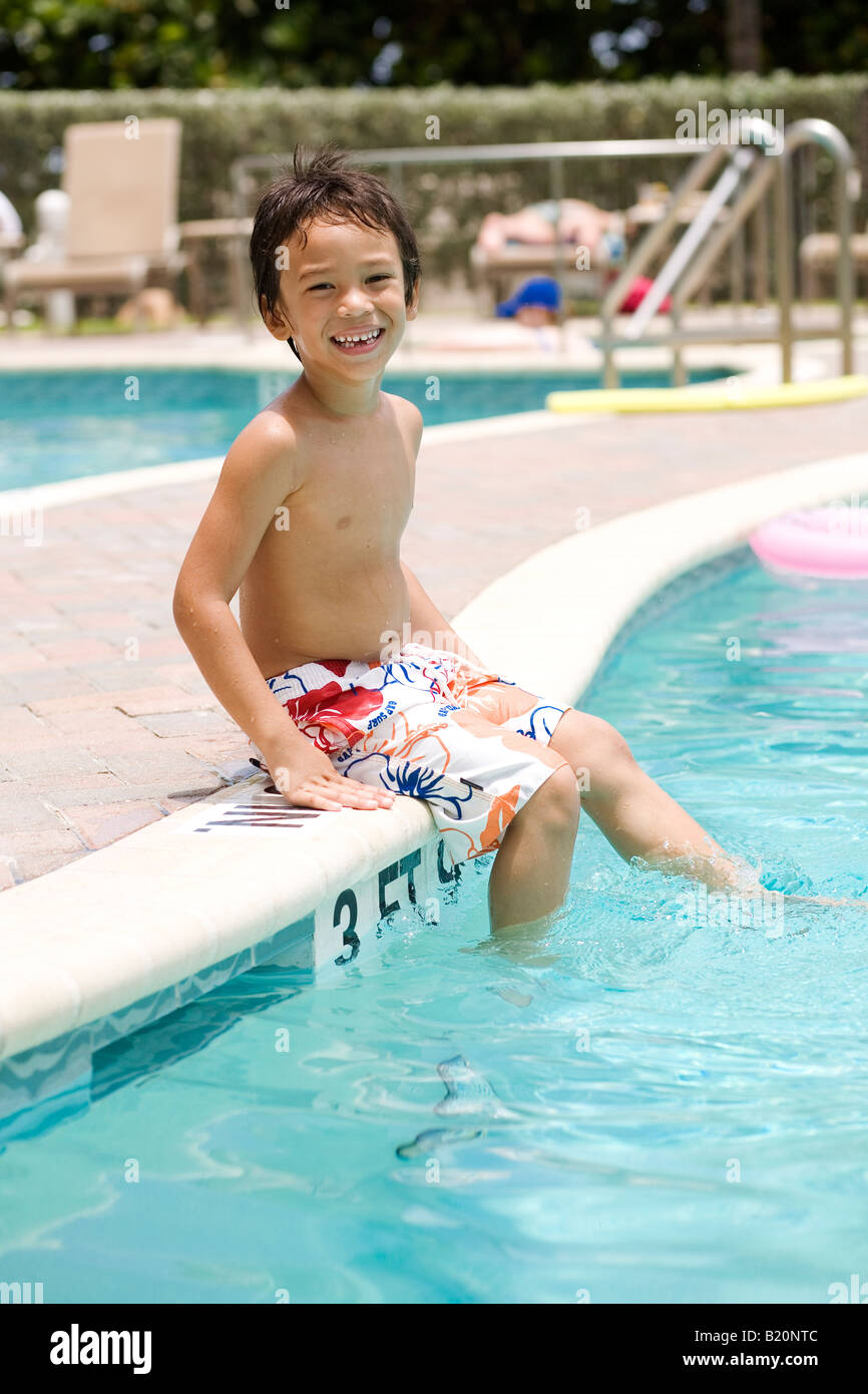 Fröhlicher Junge sitzen am pool Stockfoto