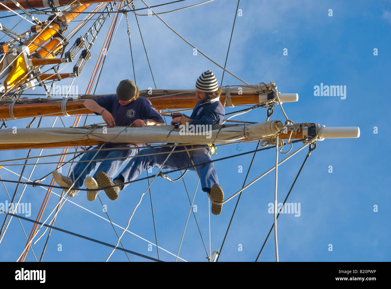 Besatzung der Großsegler Windeward Bound Biegung eine neue Segel auf einem Nock Stockfoto