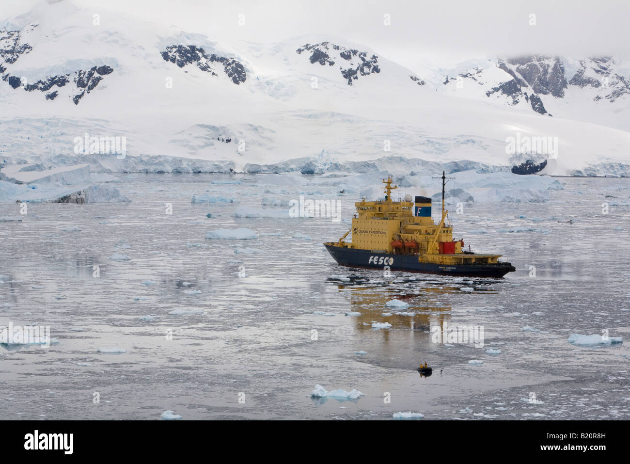 Winzige Sternzeichen von Icebreaker Kreuzfahrt in Richtung Ufer Neko Harbour Antarktische Halbinsel, Gletscher und schneebedeckte Berge, schöne Reflexionen in Eisscholle Stockfoto