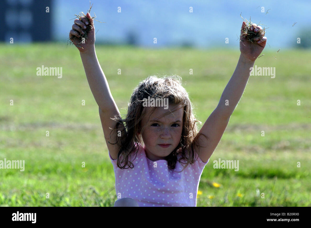 Junges Mädchen fallen Gras im wind Stockfoto