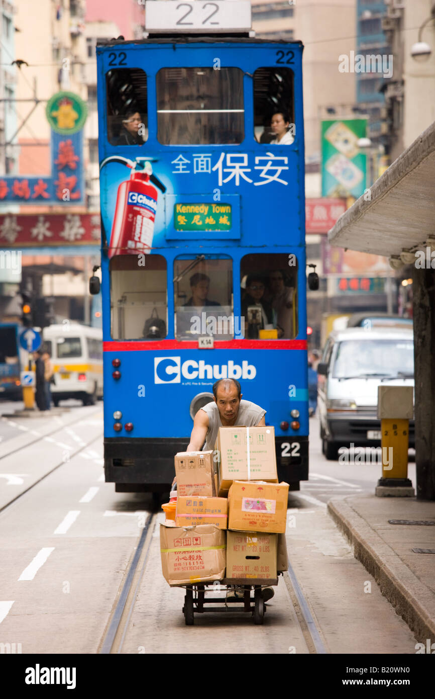Straßenbahn hinter Mann liefern Lebensmittel von Trolley in alten chinesischen Viertel Des Voeux Road Sheung Wan Hongkong China Stockfoto