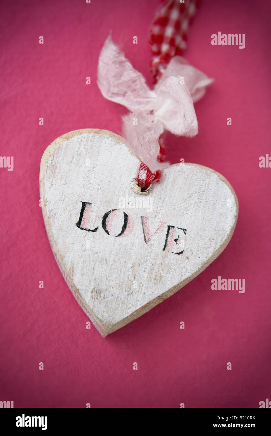 Hölzerne Liebe Herzsymbol auf farbigen Hintergrund Stockfoto