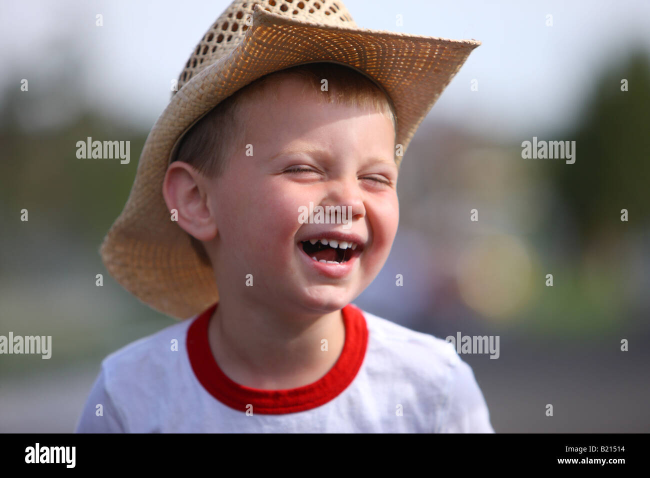 Junge mit Cowboy-Hut, Lächeln und lachen Stockfoto