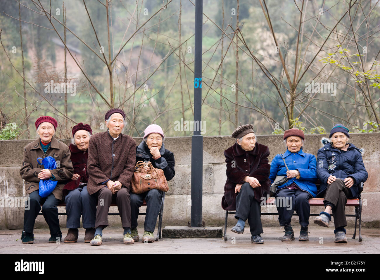Ältere chinesische Frauen zusammen sitzen auf Bänken in Chongqing, China Stockfoto