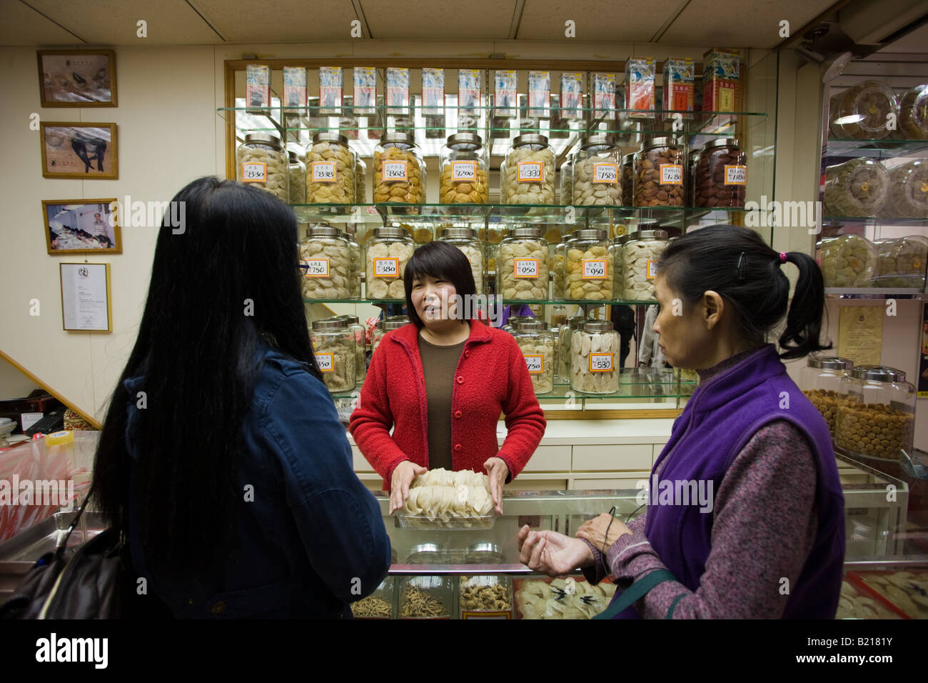 Frauen kaufen chinesische Kräuter und Medikamente im Shop in Wing Lok Street Sheung Wan Hongkong China Stockfoto