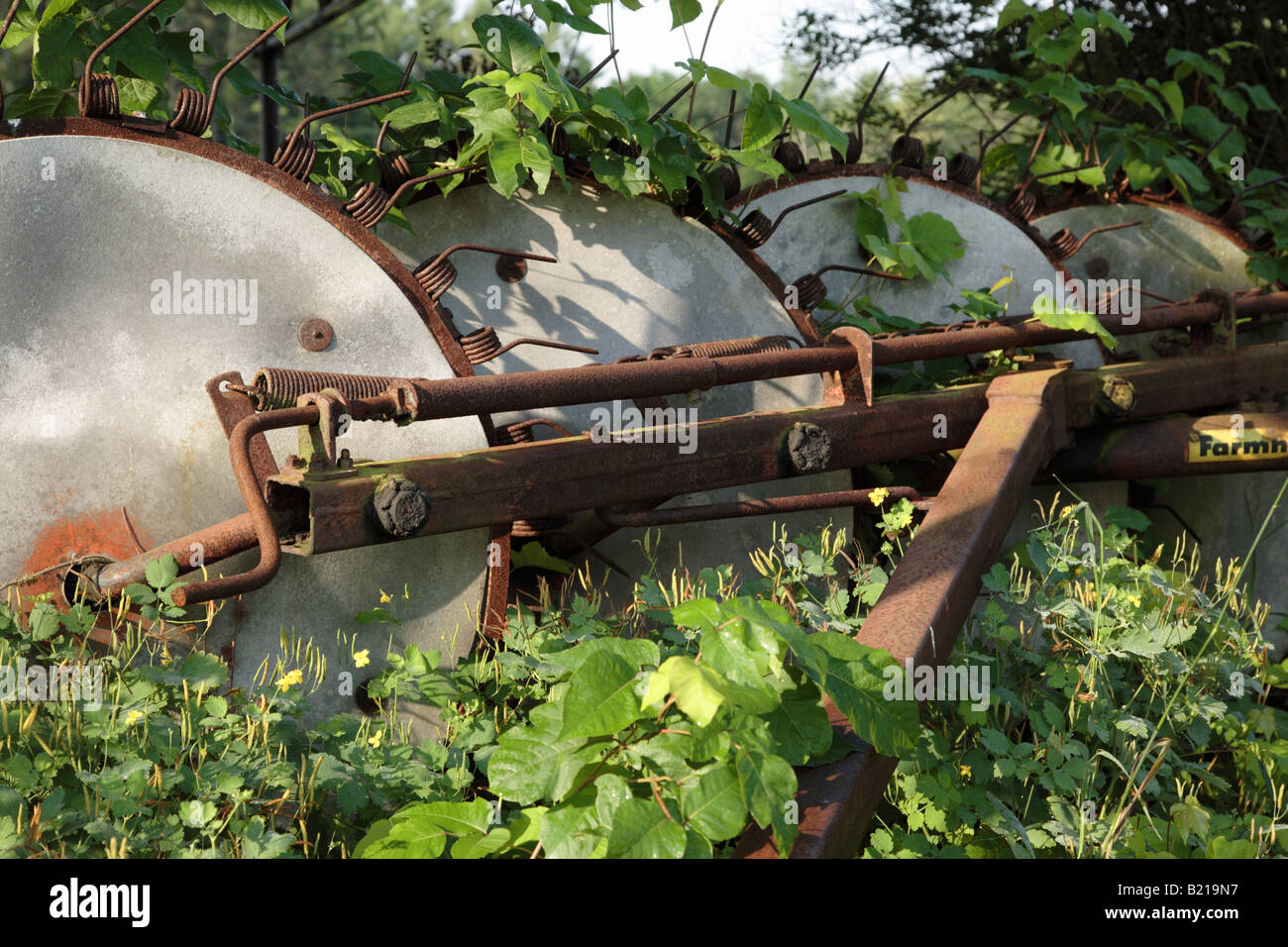 Verrostete Landmaschinen in einem Feld von New Hampshire Stockfoto