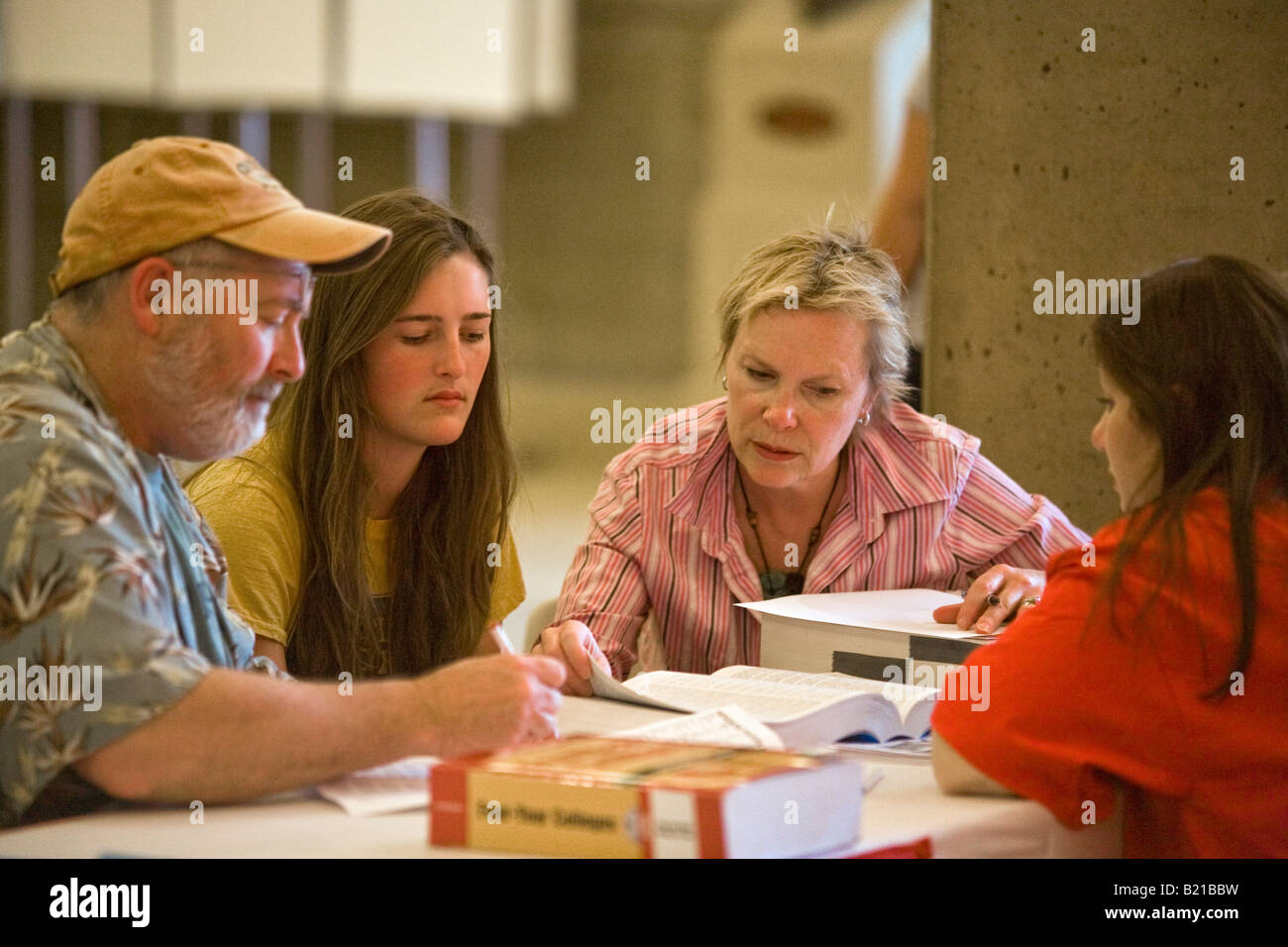 Ein High-School-Schüler und ihre Eltern diskutieren ihre Auswahl an Hochschulen mit einem Berater an einem College-Messe in Los Angeles Stockfoto