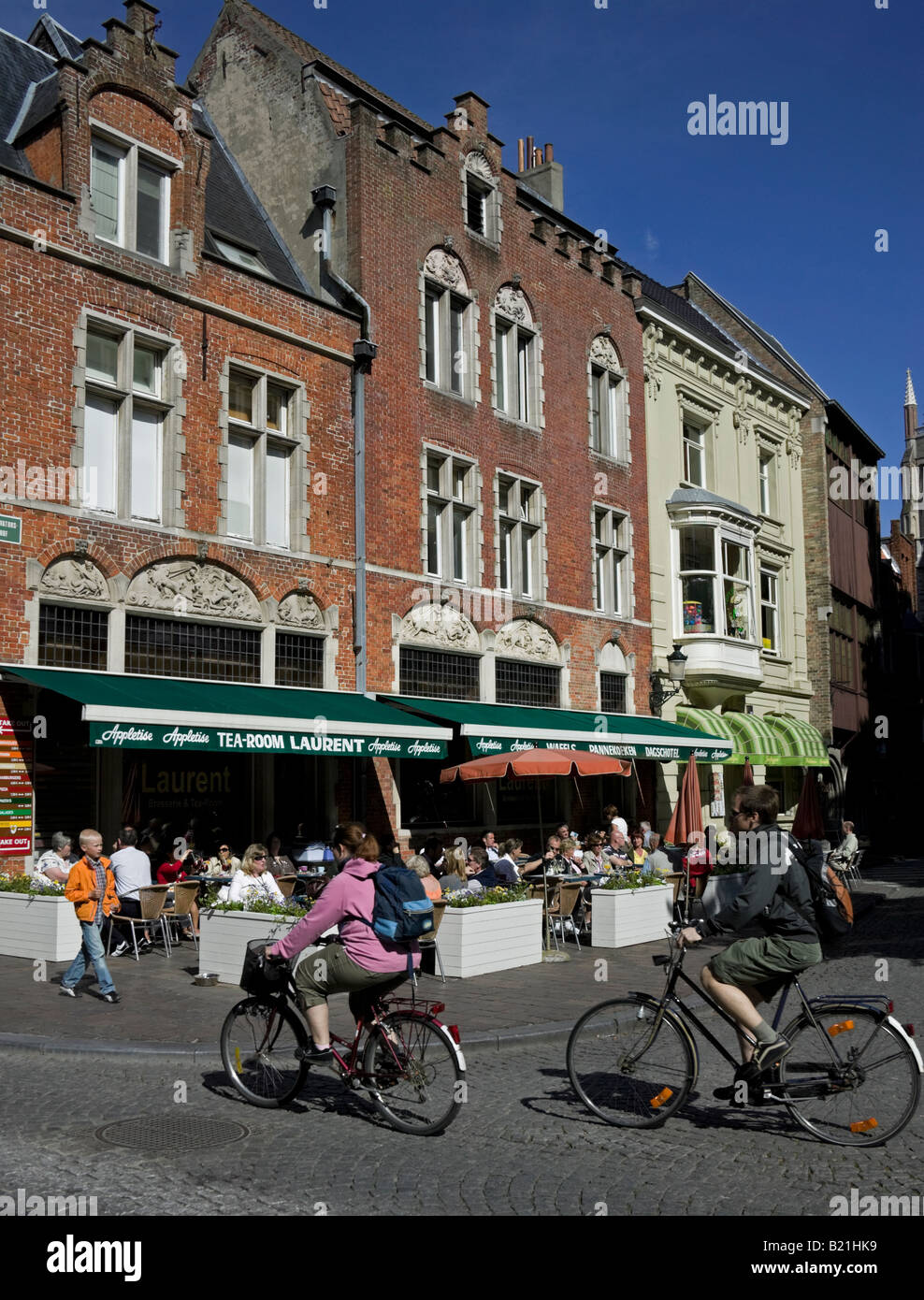 Männliche und weibliche Radfahrer vorbei Restaurants, Brügge, Brügge, Belgien, Flandern, Europa Stockfoto