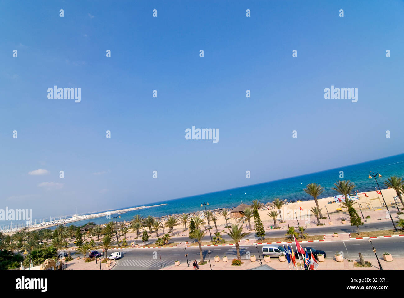 Horizontale erhöhten Weitwinkel über den langen Sandstrand im Yasmine Beach Resort in Hammamet vor blauem Himmel Stockfoto