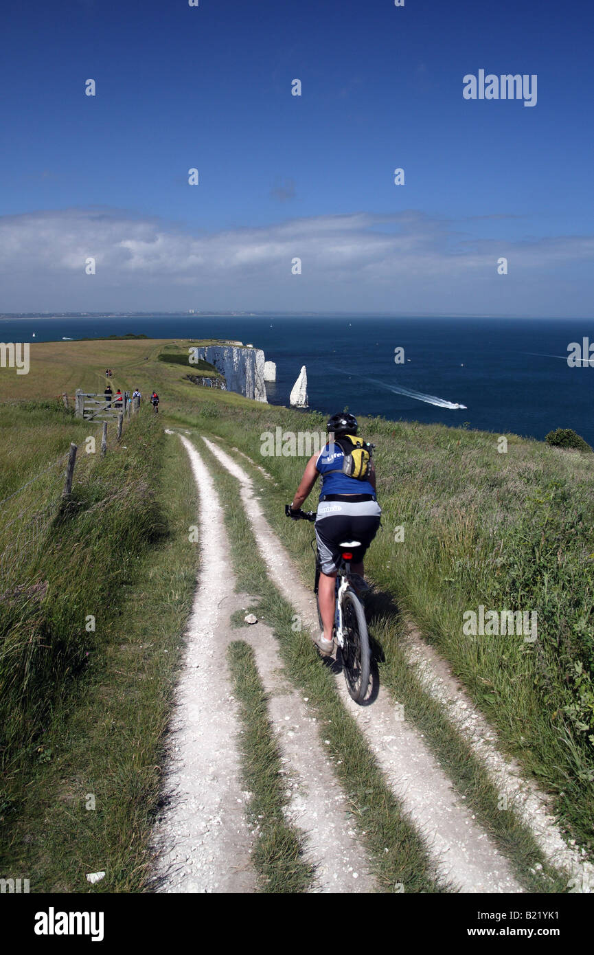 Eine Frau, Radfahren auf dem Weg zur alten Harry Felsen in der Nähe von Poole in Dorset in England Stockfoto