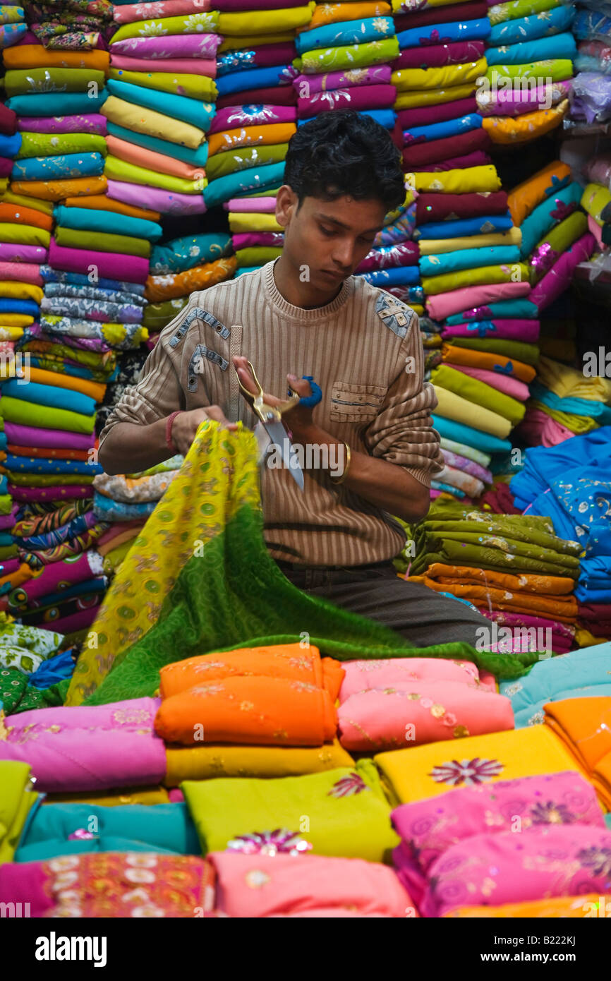 Ein Mann arbeitet in einem Stall auf dem SARI CHANDNI CHOWK OLD DELHI Indien Stockfoto