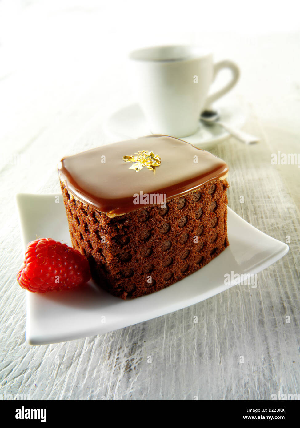 Eine handgemachte Patisserie Spezialität reichen verwöhnenden Schokoladenkuchen mit Kaffee in einem weißen Setting Stockfoto