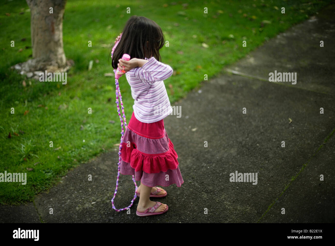 Mädchen im Alter von vier lernen, Hinweis überspringen geschützten Disney Springseil Stockfoto
