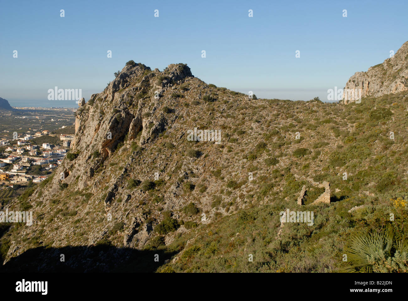 Ruine am Hang & Stadtentwicklung, in der Nähe von Pedreguer, Marina Alta, Provinz Alicante, Comunidad Valenciana, Spanien Stockfoto