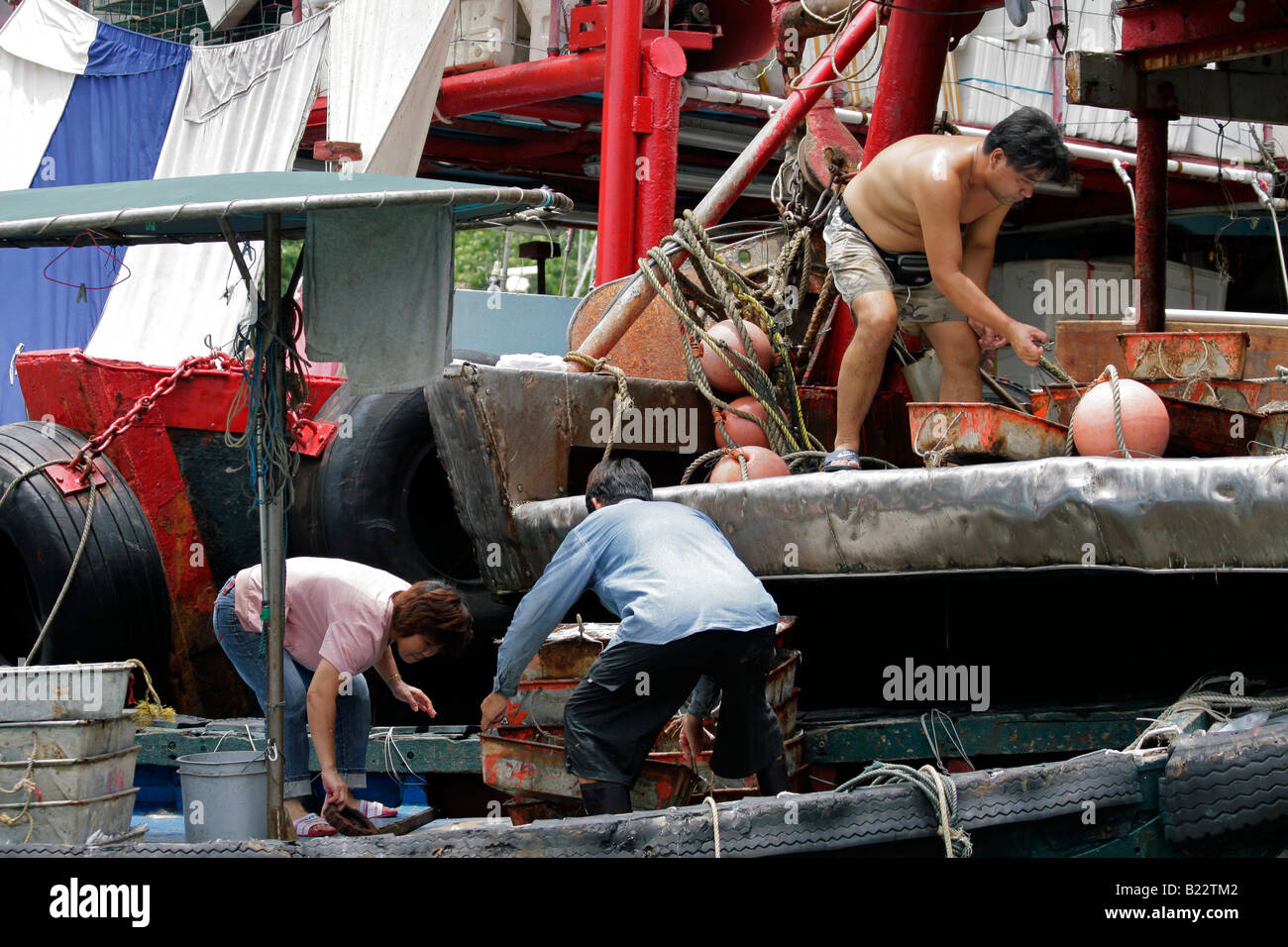 Chinesische Boot Leute entladen Fisch Körbe, Causeway Bay, Hong Kong Insel, China Stockfoto