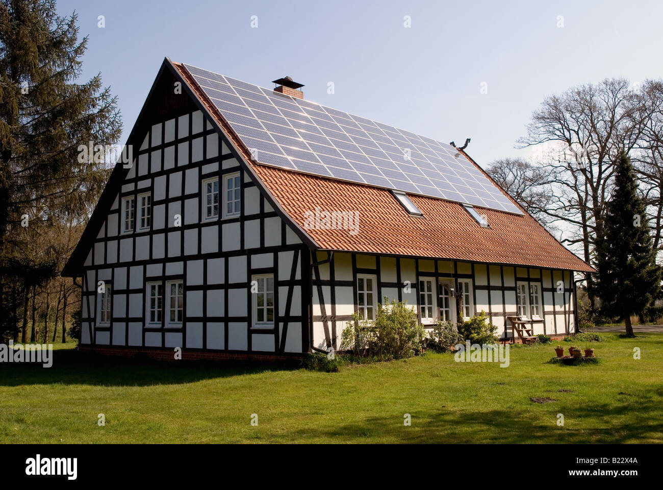 Traditionelles Fachwerk gerahmte Haus mit PV-Modulen versorgen das Haus mit elektrischem Strom, Strohen, Niedersachsen, Deutschland. Stockfoto