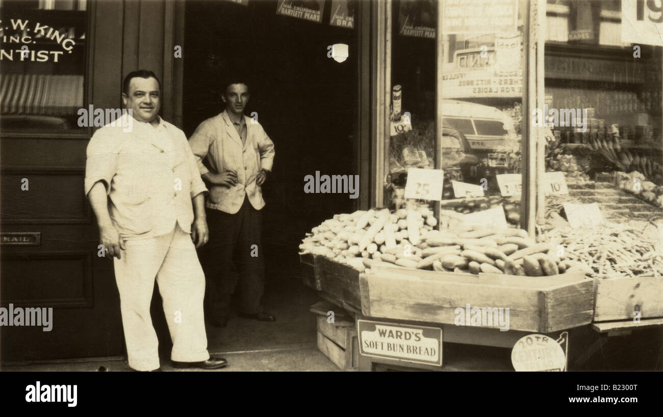 Um 1940er Jahre antike Fotografie eines Viertels Lebensmittelgeschäft und Gemüse Stand mit alten Werbeschildern sichtbar. Wahrscheinlich Massachusetts oder Connecticut. Stockfoto