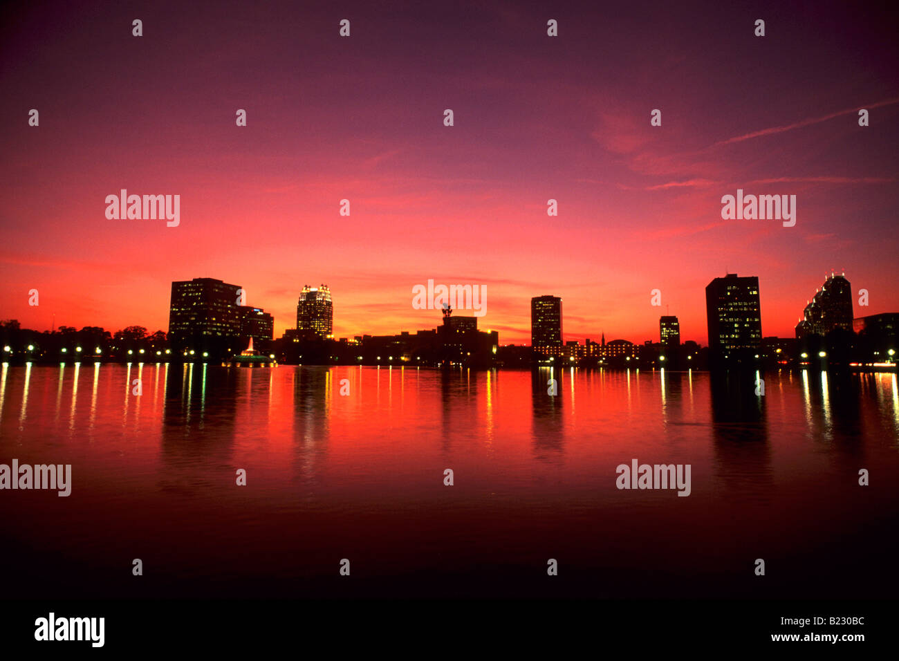 Reflexion von Gebäuden im Wasser in der Abenddämmerung, Lake Eola, Orlando, Orange County, Florida, USA Stockfoto