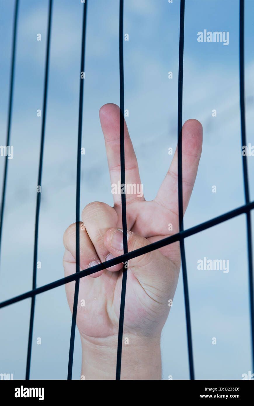 Victory-Hand-Zeichen hinter Gittern Stockfoto