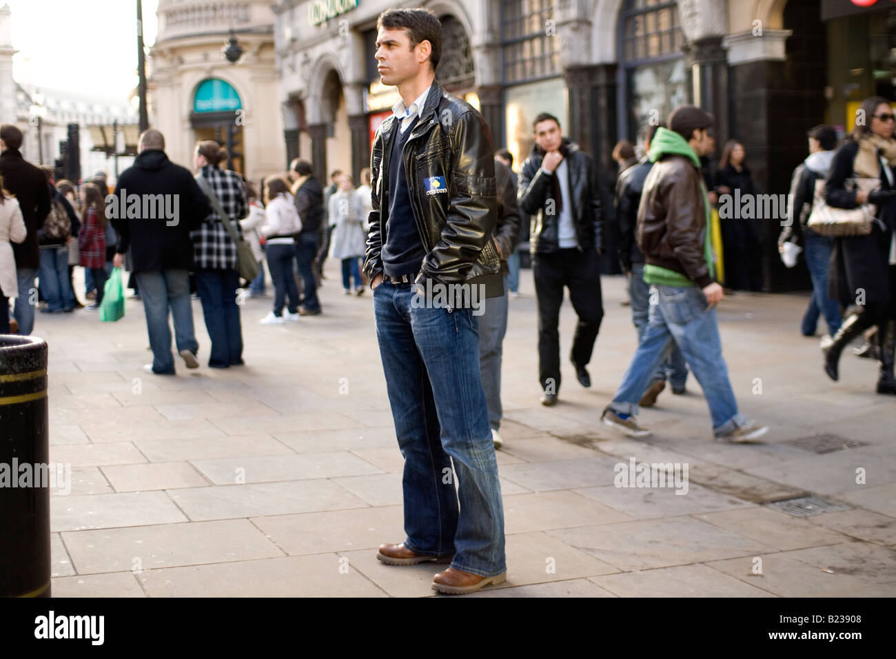 Ein Mann wartet in einer belebten Straße in London Stockfoto