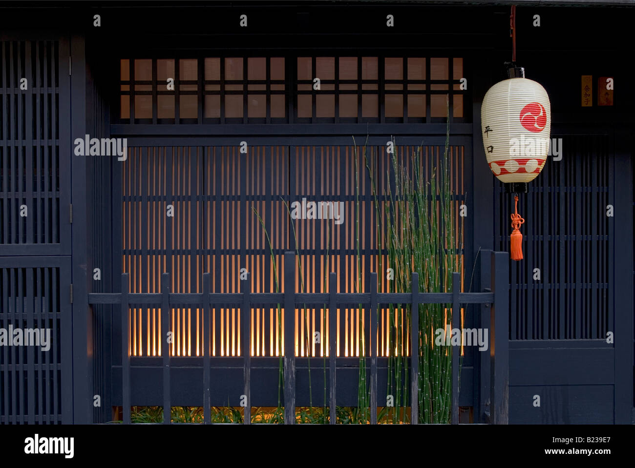 Warmes Leuchten hinter dem „Koshi“-Gitter eines traditionellen Machiya-Stadthauses im Gion Shimbashi-Viertel von Kyoto, Japan. Stockfoto