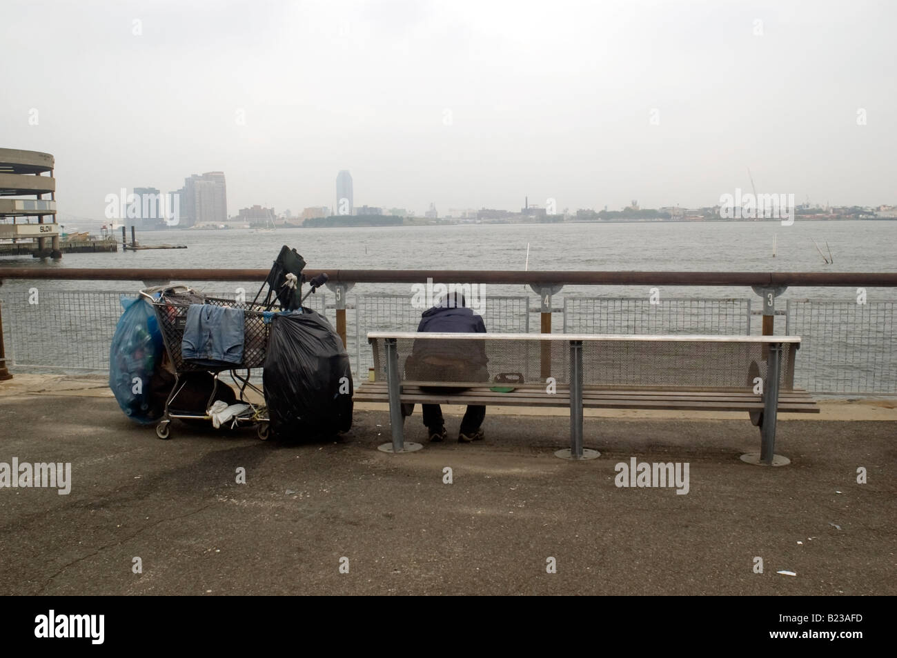 Ein Obdachloser sitzt in Stuyvesant Cove Park in New York NY Stockfoto