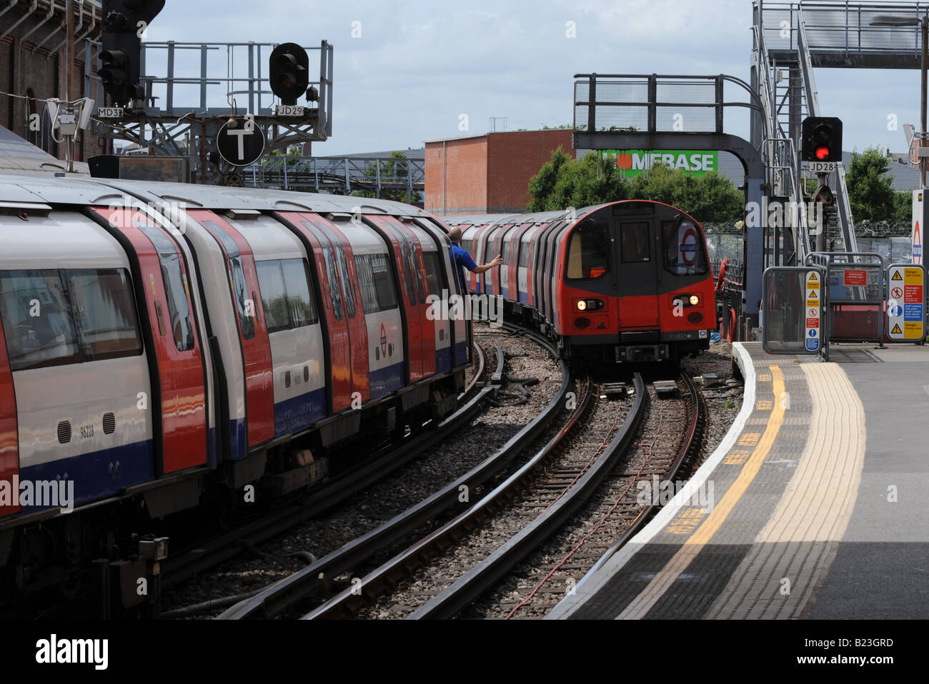 Londoner U-Bahn Züge in Finchley Road Station. Ein Treiber ist für den Fahrer des anderen ankommenden Zug winken Stockfoto