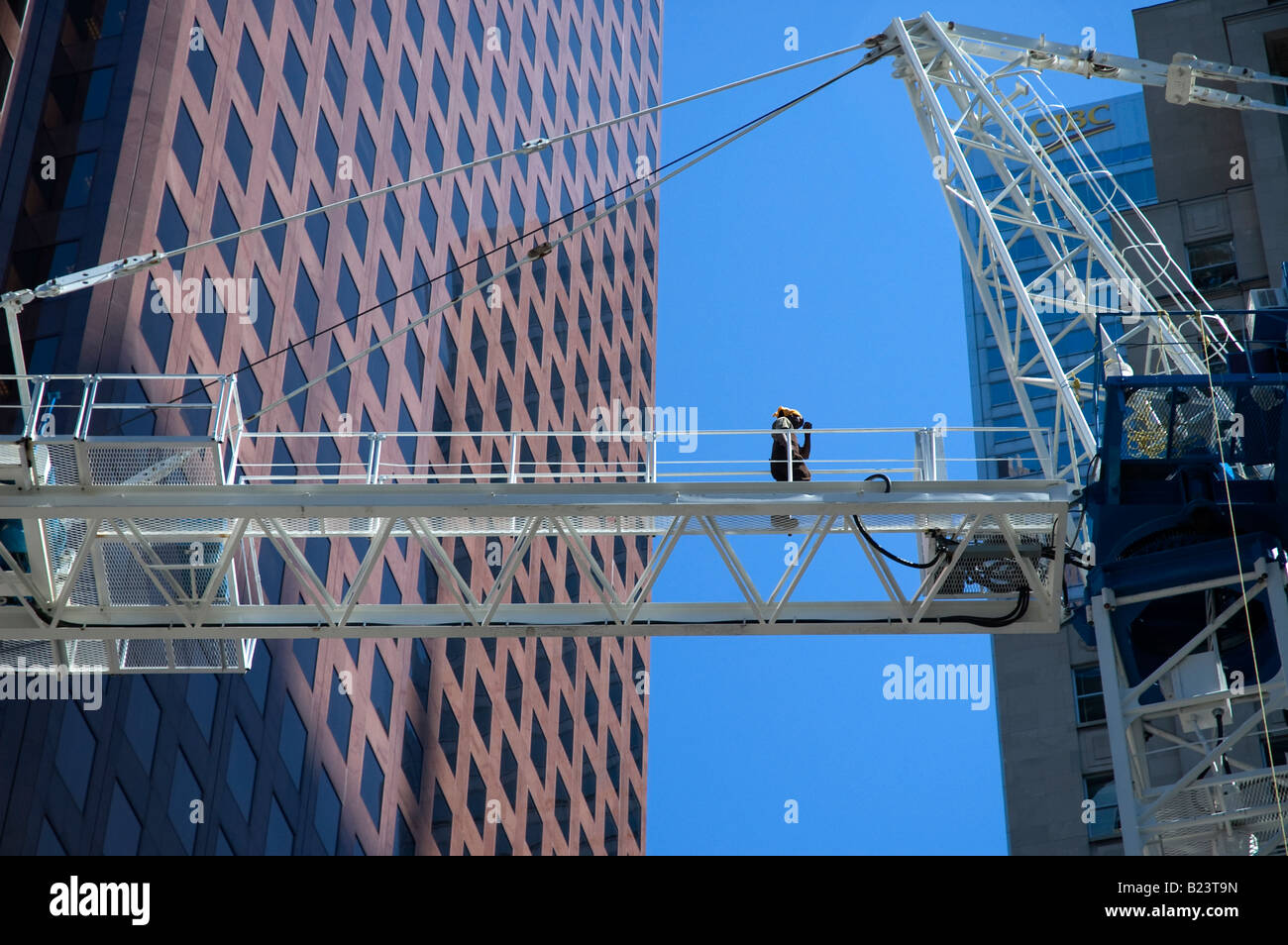 Arbeiter geht durch Turmdrehkran auf Baustelle. Stockfoto