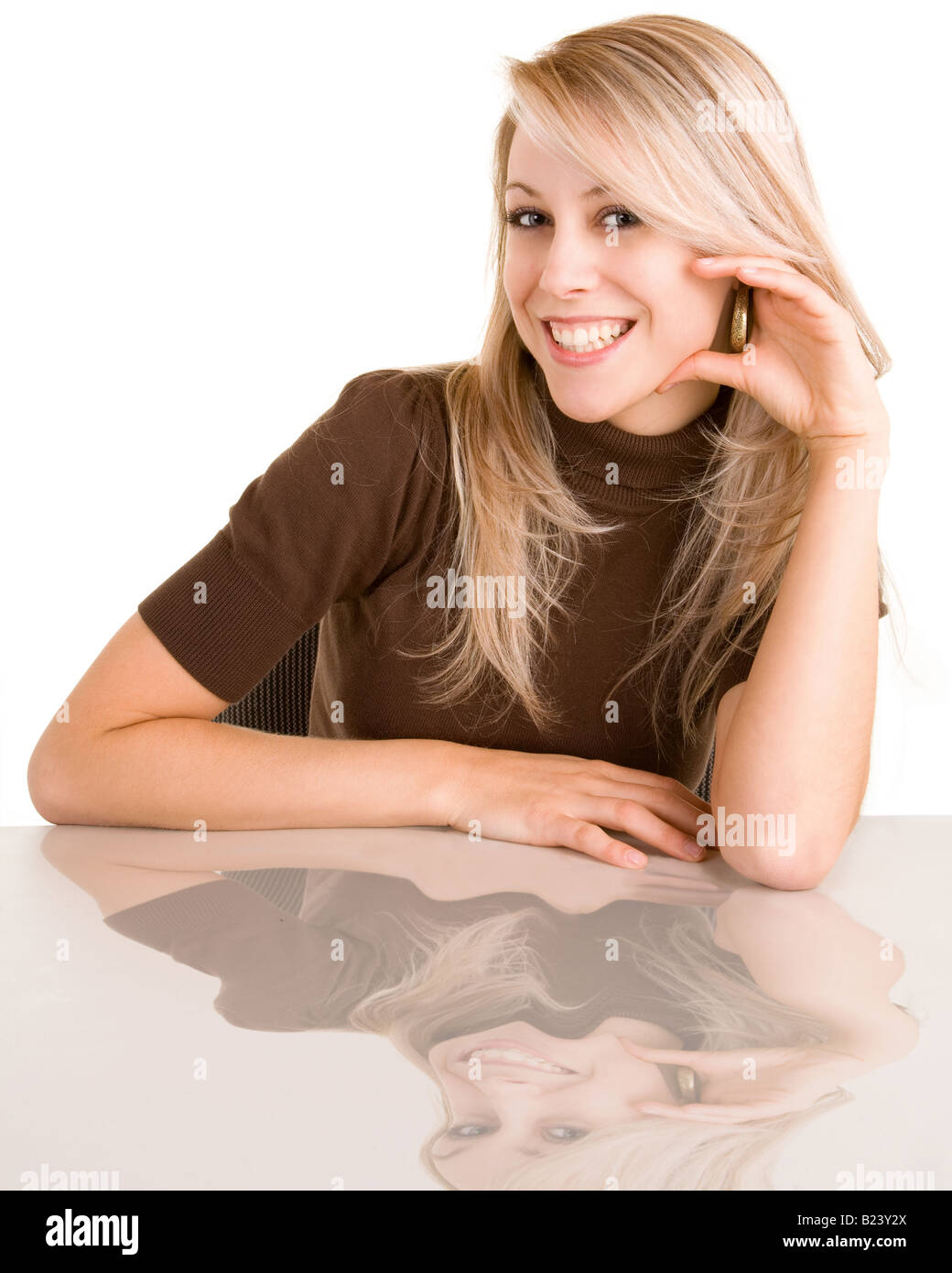 Porträt einer schönen lächelnden Dame sitzt an ihrem Schreibtisch Stockfoto